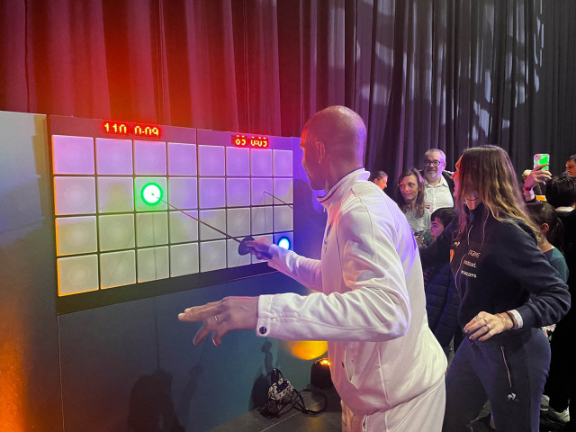 Homme faisant de l'escrime sur un mur intéractif